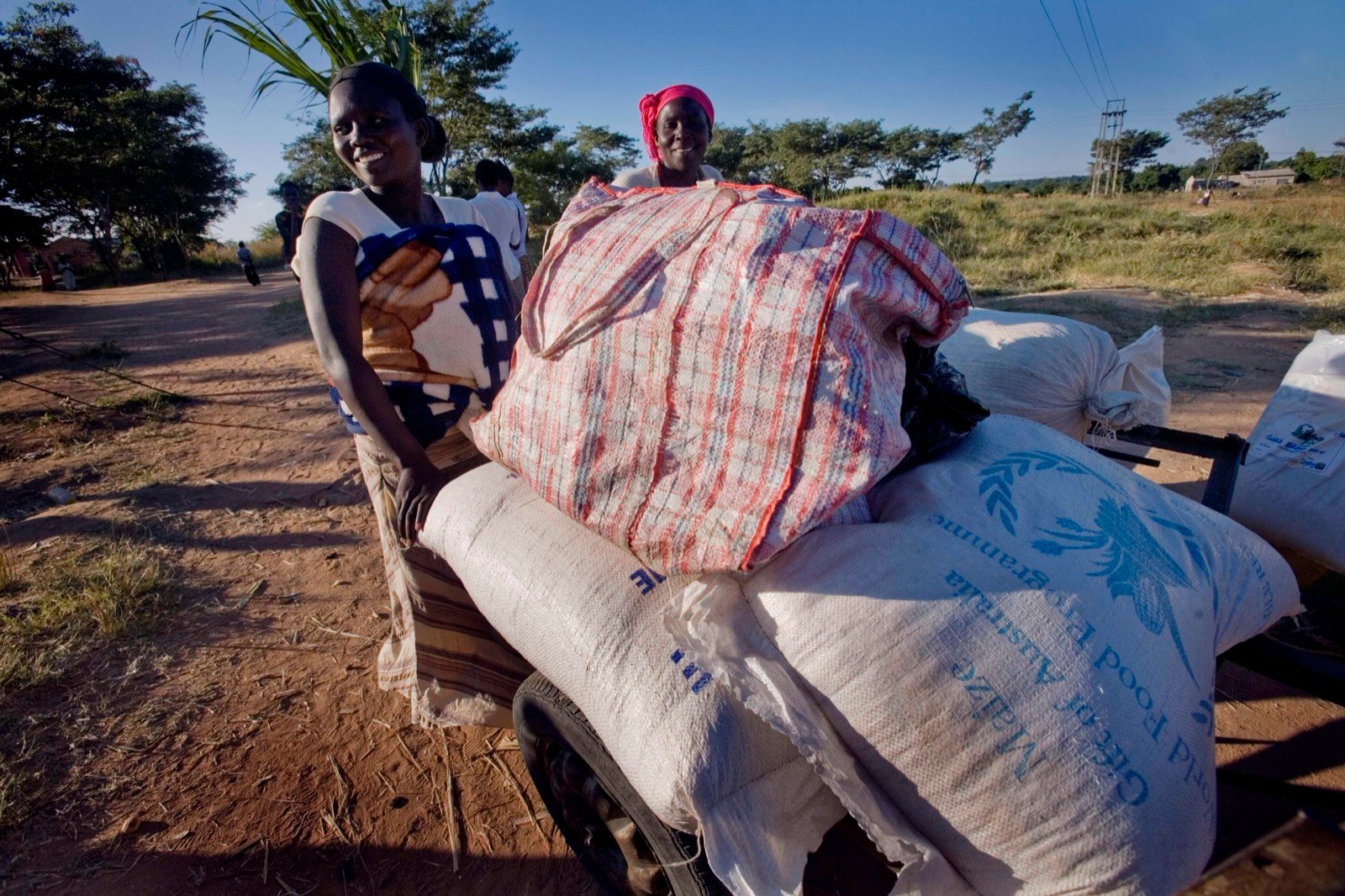 A woman carrying a sack of grain home from a distribution point